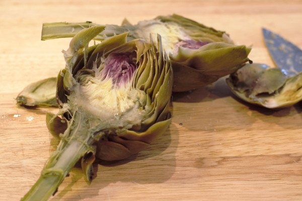 Artichokes halved after steaming. The center of the artichokes are very tender and ready for cleaning.
