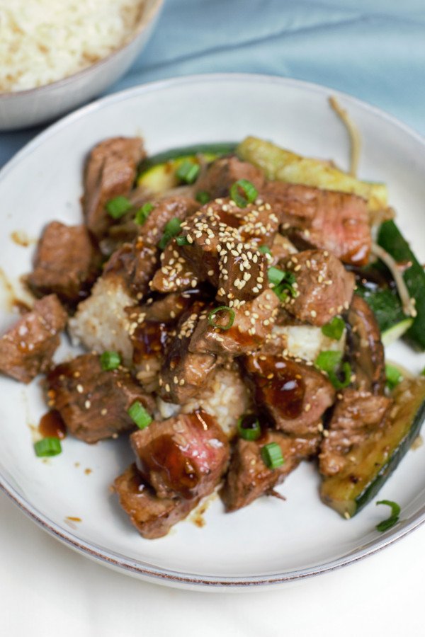 Sliced Teriyaki Steak over steamed rice with grilled zucchini and bean sprouts. 