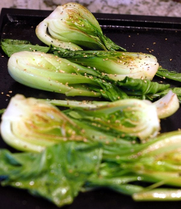 Baby Bok Choy is grilled on one side and brown along the edges.