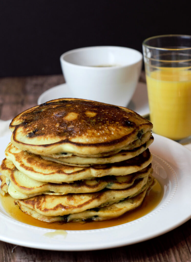 stack of blueberry ricotta pancakes with coffee and juice