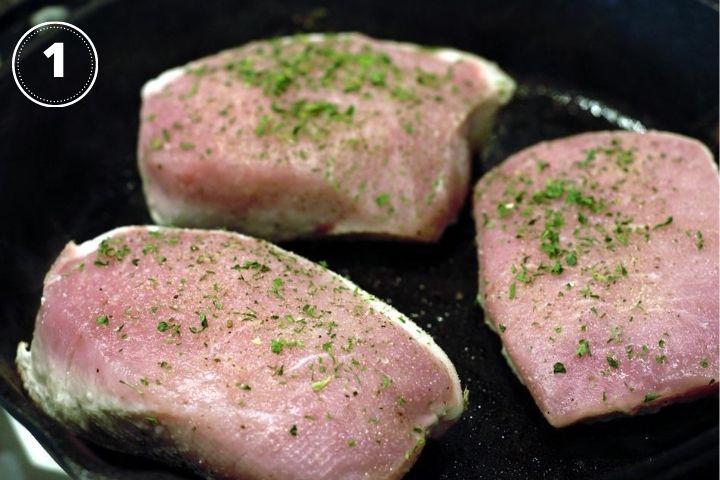 raw pork chops in cast iron pan
