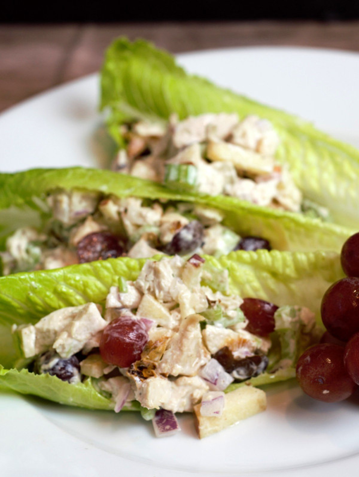 waldorf salad in romaine lettuce cups on white plate
