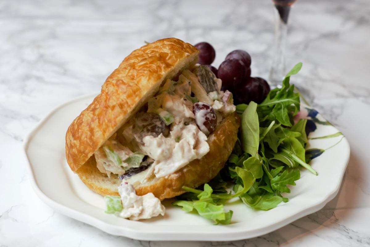 waldorf croissant sandwich on white plate.