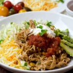 close up shredded chicken filling with taco toppings
