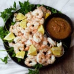 shrimp cocktail with cocktail sauce lemon wedges on black plate