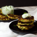 cooked zucchini fritters with green onion dip on top