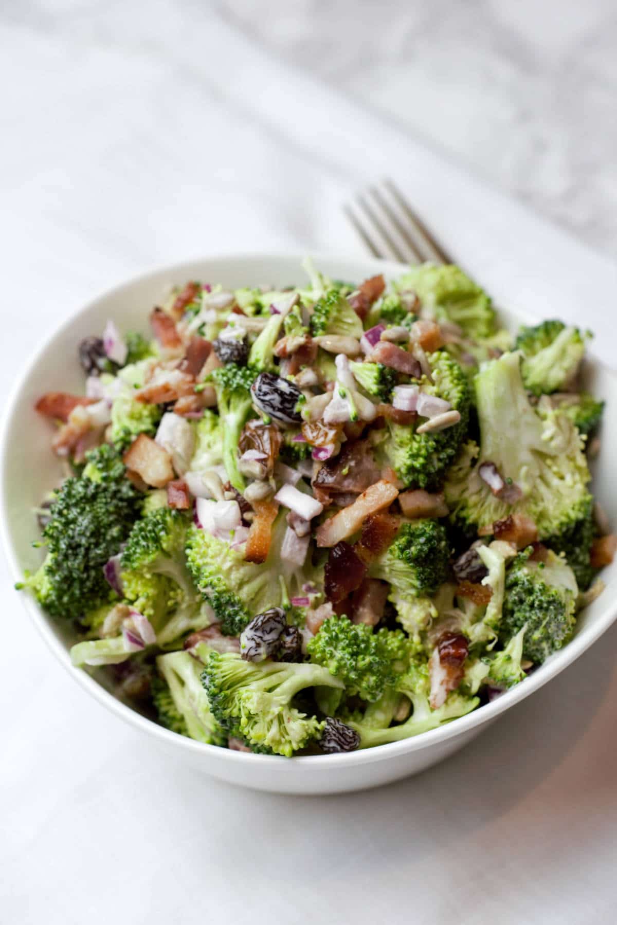 close up broccoli crunch salad in white bowl