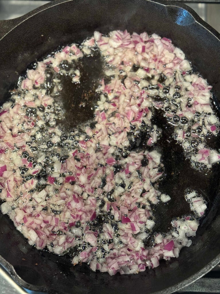 finely diced red onion in a skillet of hot bacon grease