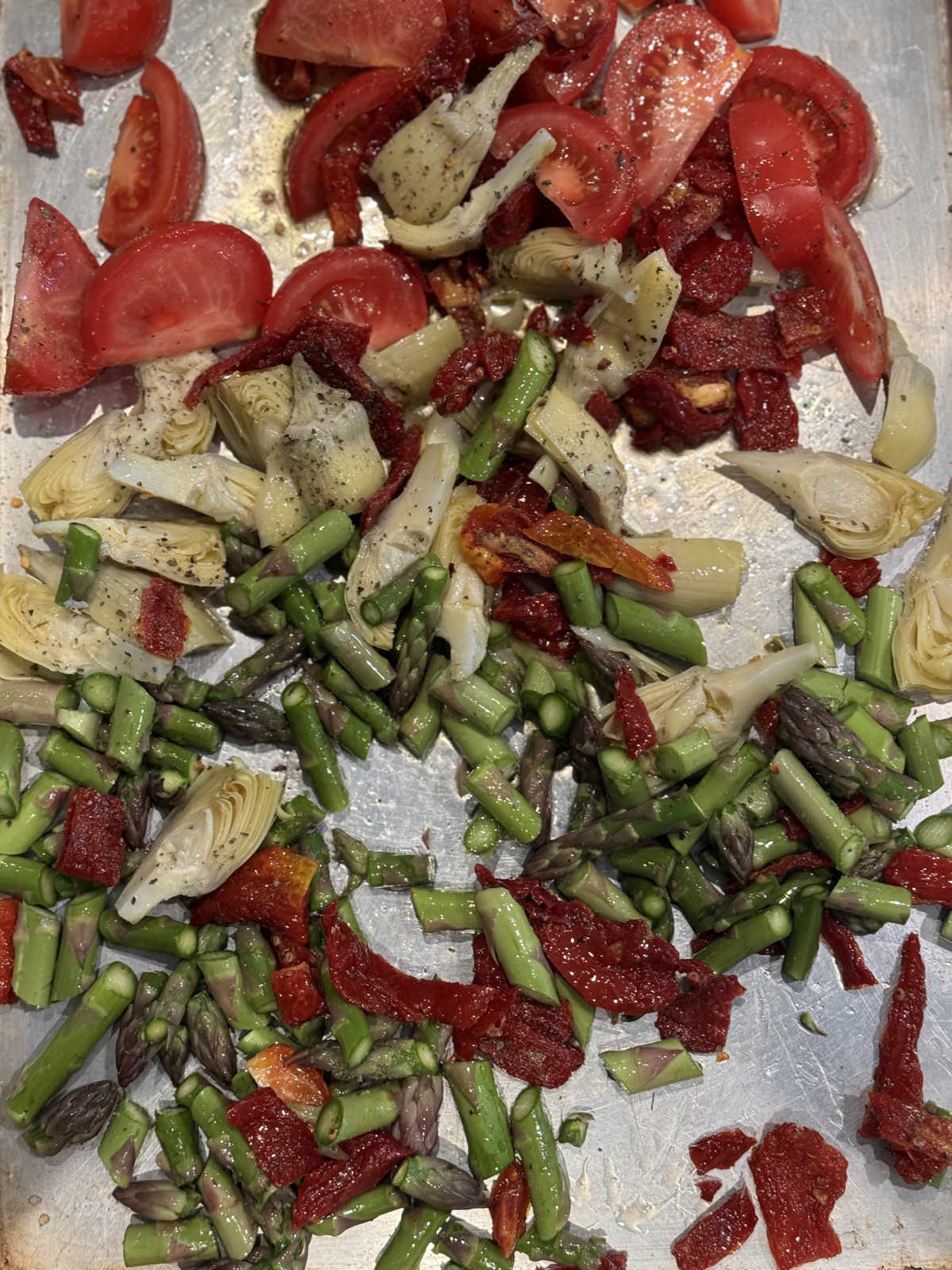 vegetables on sheet pan with olive oil and seasoning