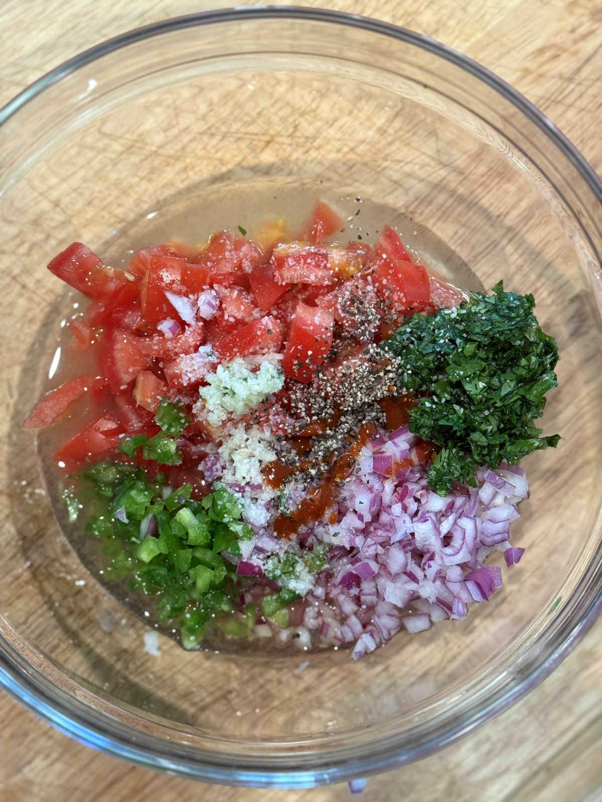 chopped vegetables, lime juice, and seasoning in a glass bowl