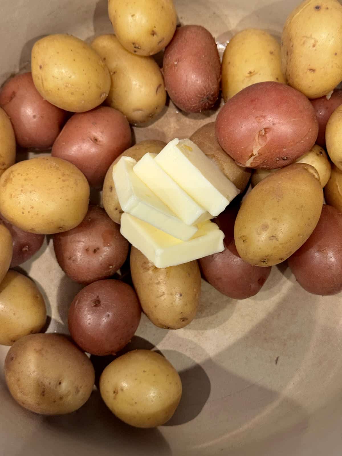drained potatoes in pot with butter