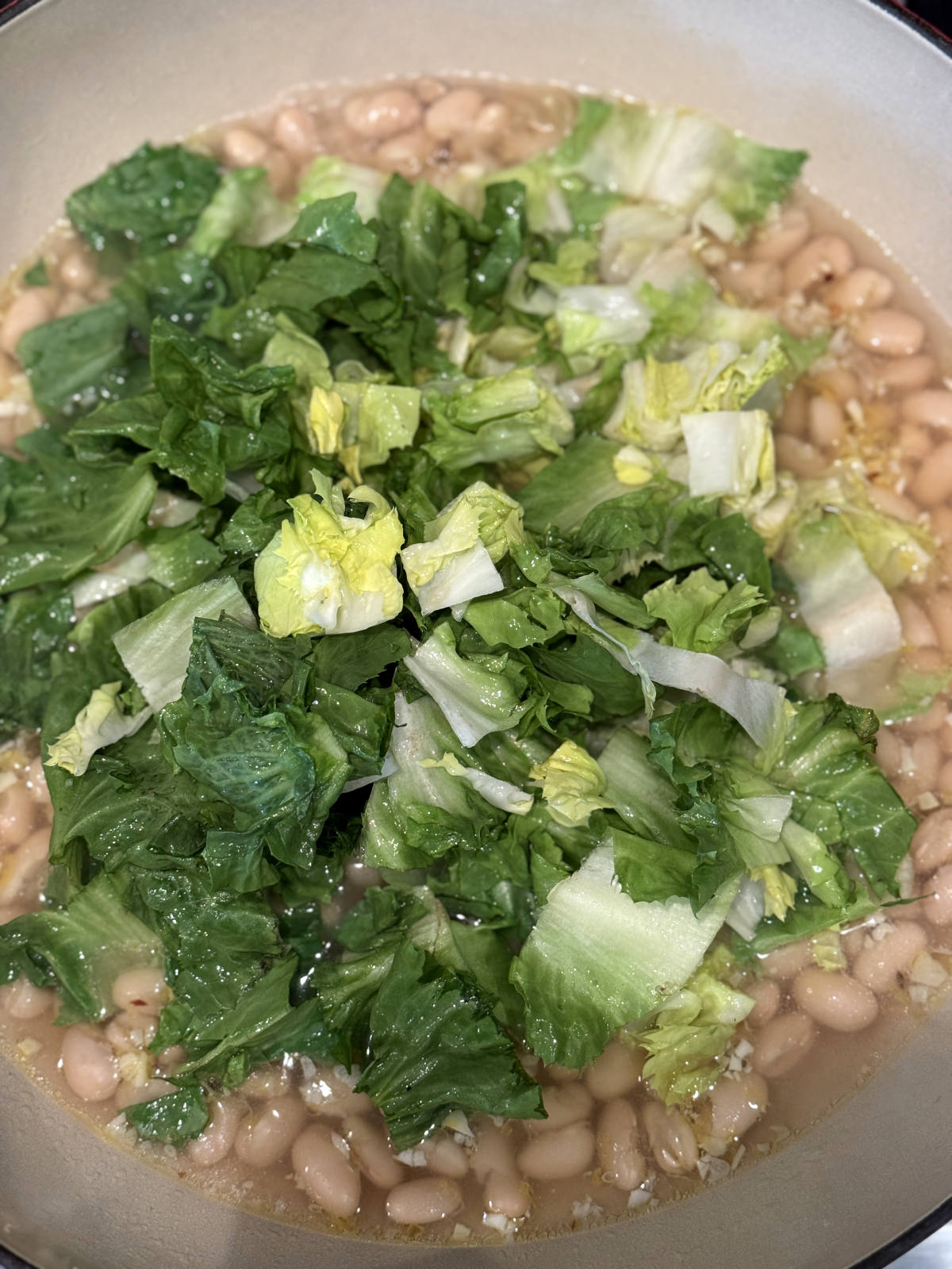 cannellini beans in broth with chopped escarole on top