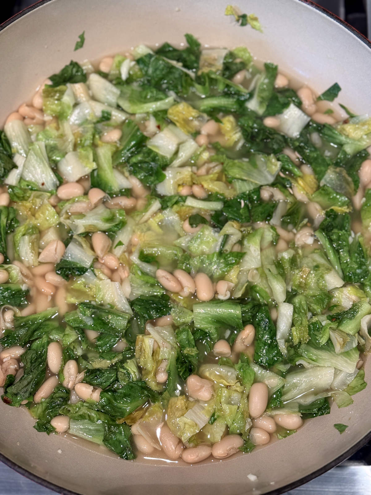 Cooked beans and greens in a Dutch oven