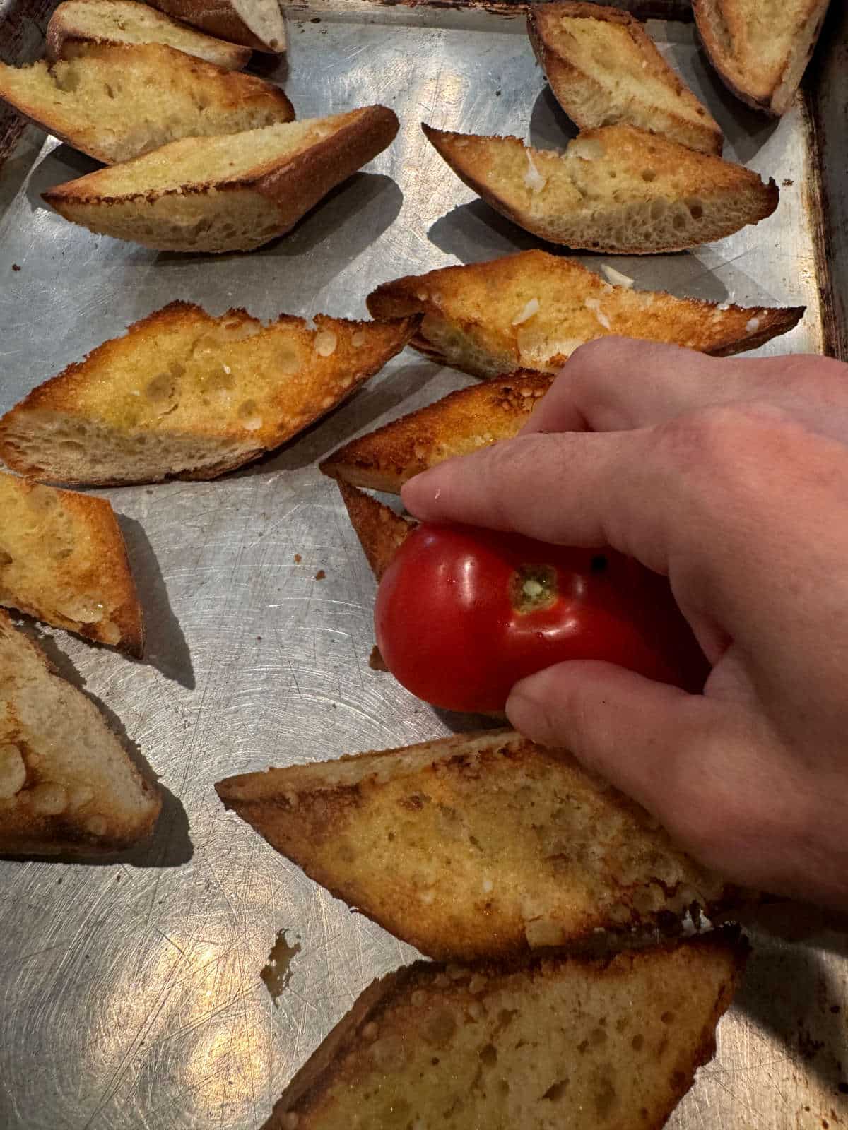 rubbing half a tomato on French bread