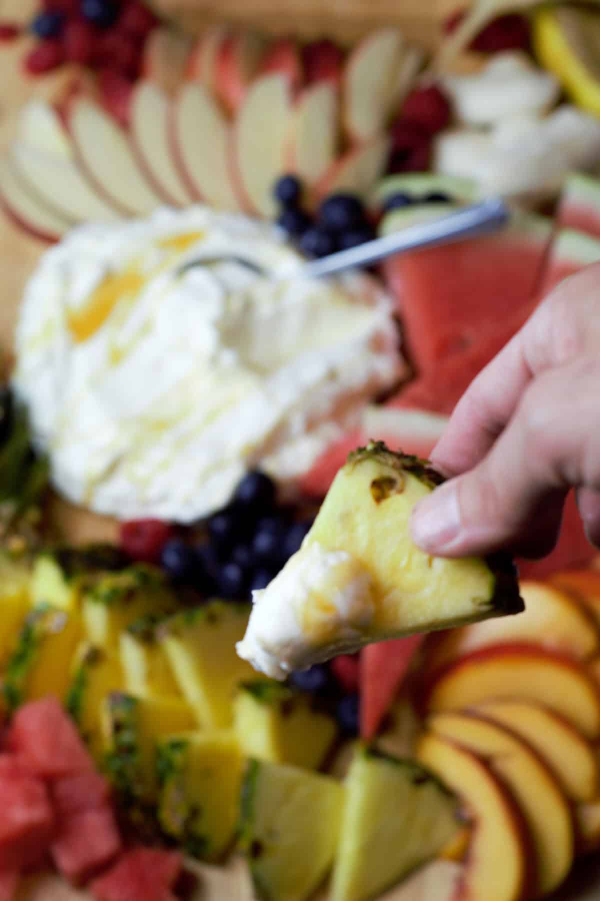 close up pineapple wedge with fruit dip