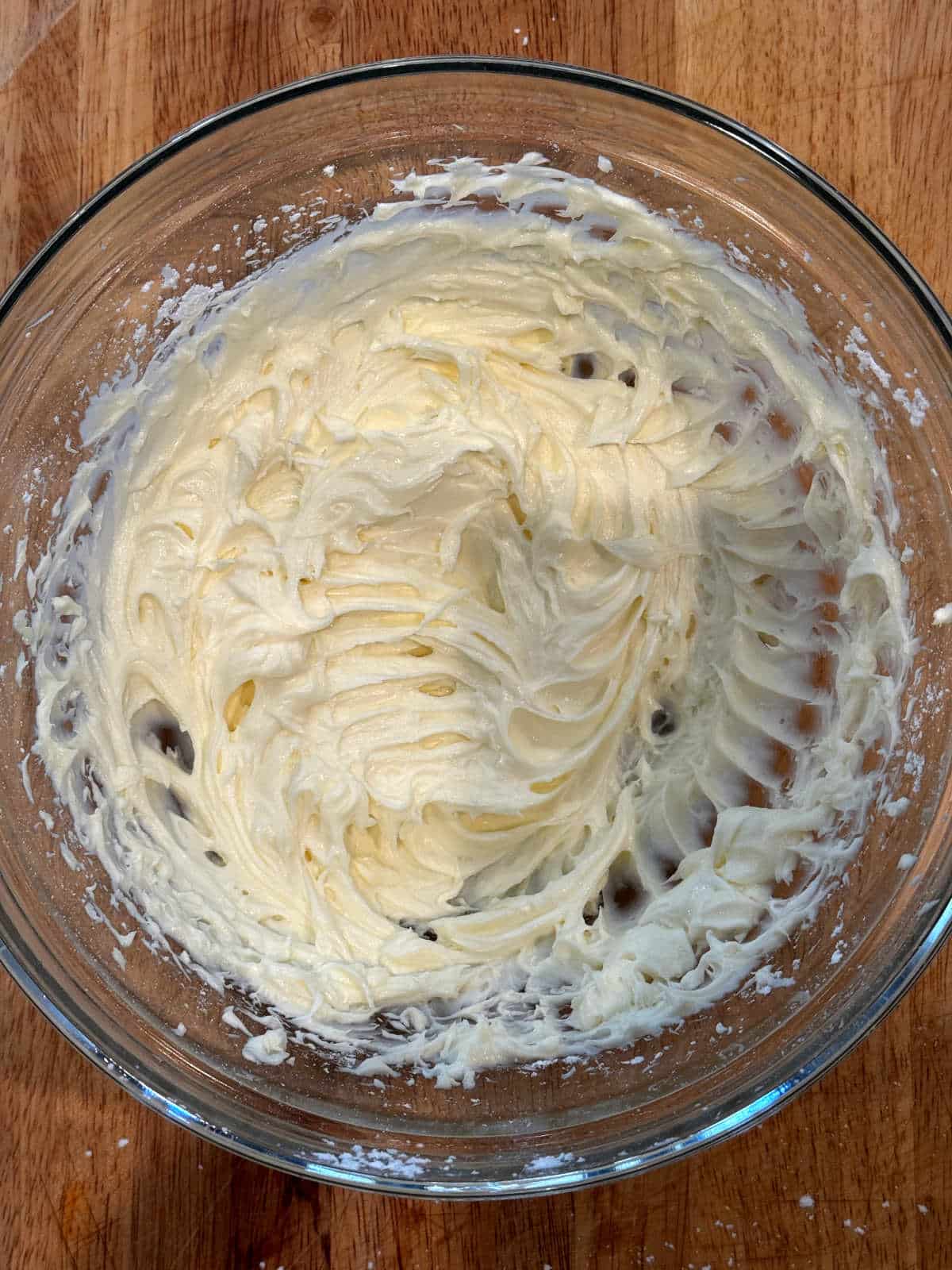 whipped cream cheese and powdered sugar in glass bowl
