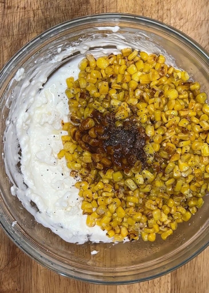 toasted corn added to cream dip base in bowl