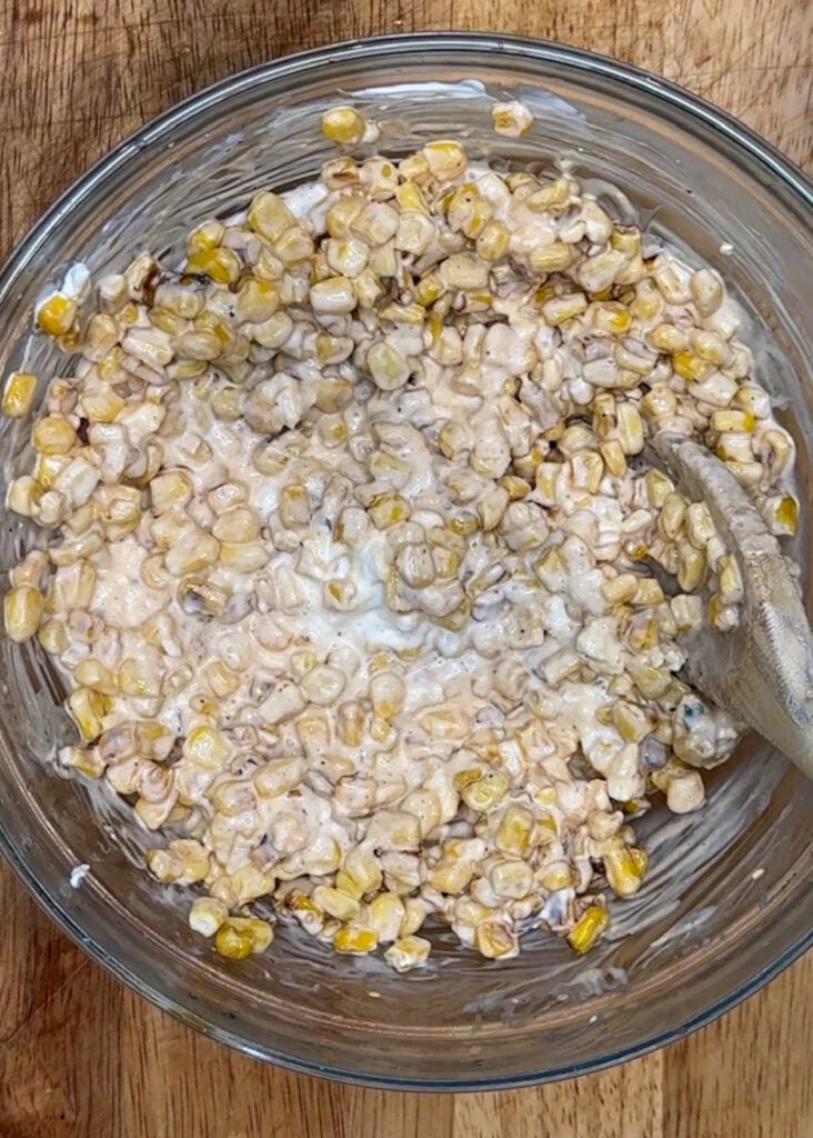 Corn dip mixed in a glass bowl