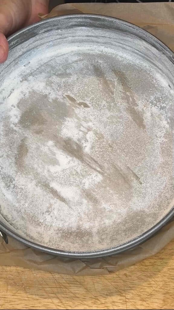 springform pan prepared with butter and sugar for nonstick